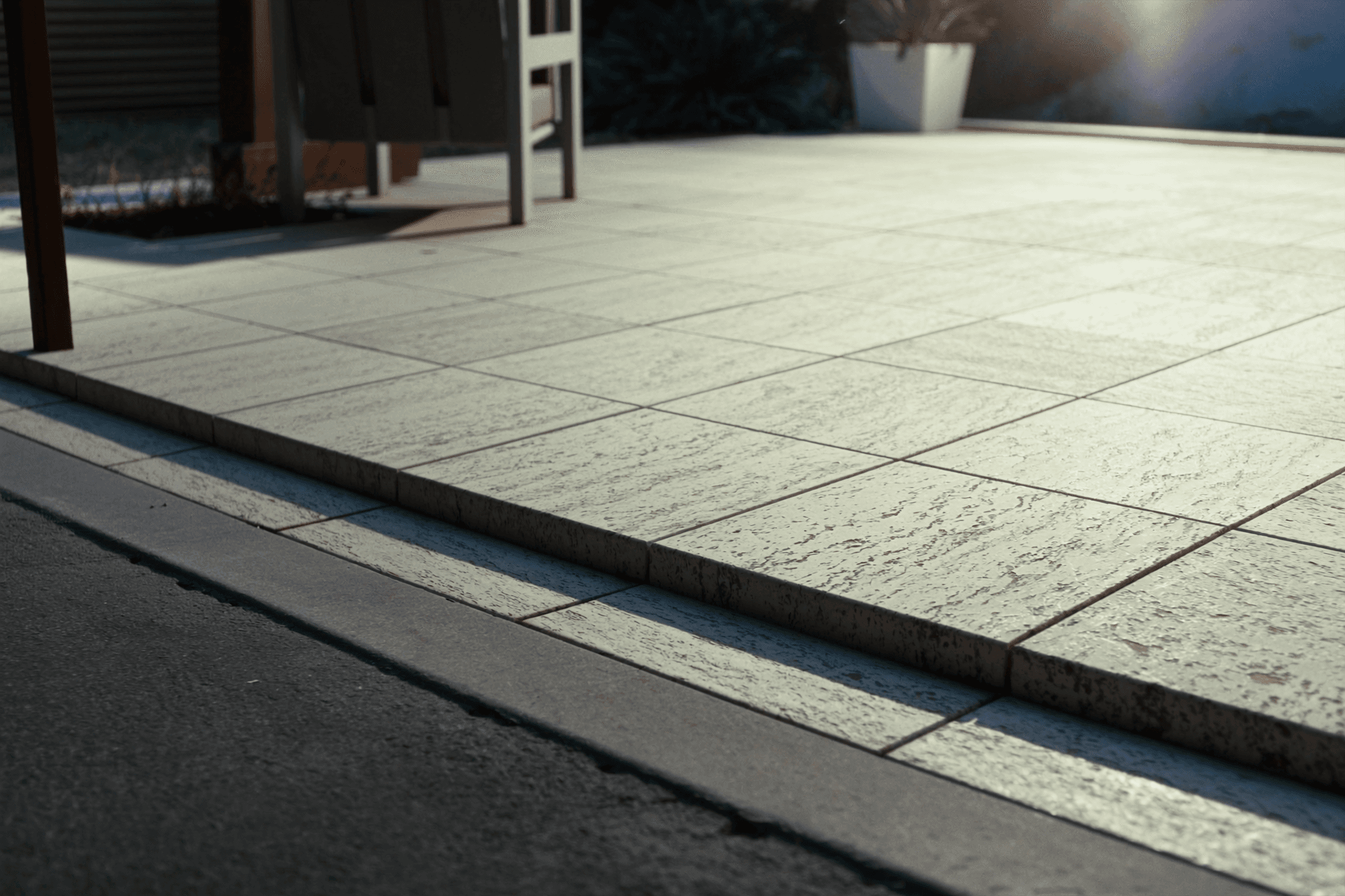 Close-up of paver installation — pavers laid in a herringbone pattern over a compacted base